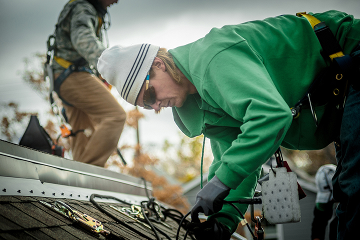 man installing solar panels on a roof