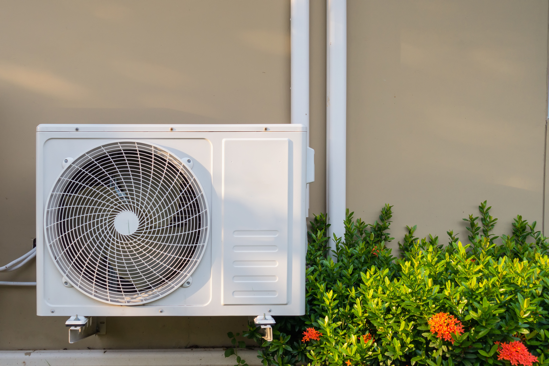 split air conditioner outside home by bushes