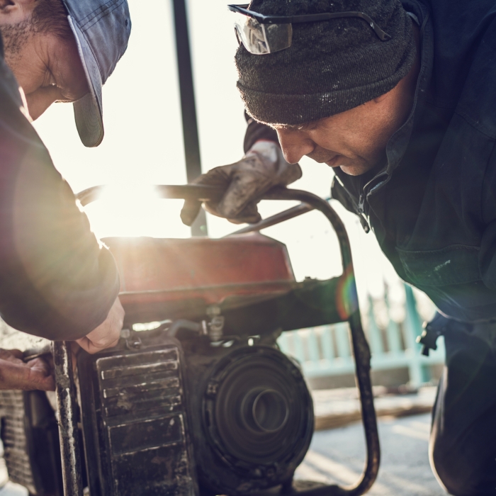 Two men working on a generator